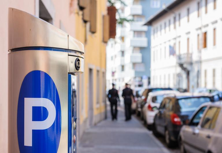 parking machine on a street with parked cars