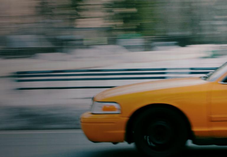 Taxi driving quickly across landscape.