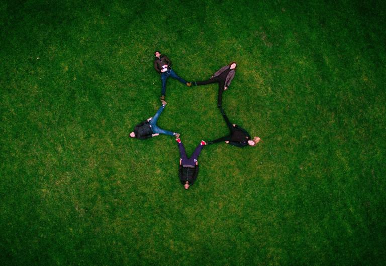 five people connecting to make a star